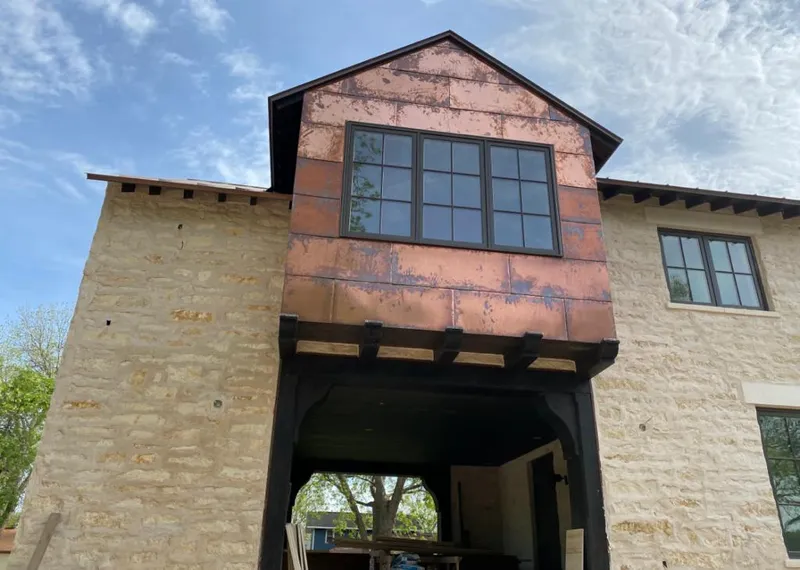 Copper metal panel facade on a stone building for Roof Repair in Parsons